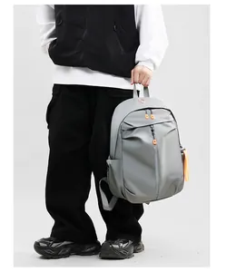 Close-up of waterproof grey backpack with vibrant orange zippers and decorative strap detail
