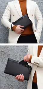 Detail of black pebbled leather clutch bag showing back zipper pocket and smartphone storage