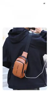 Detail of brown leather chest bag with USB charging port and pebble grain texture