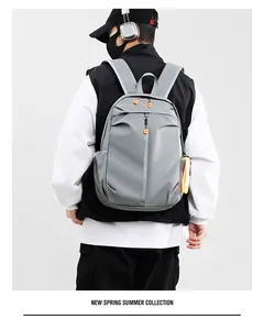 Macro detail of waterproof grey backpack featuring vibrant orange zipper pulls for men and women