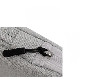 Macro detail of high-quality metal zipper and durable fabric on grey laptop sleeve