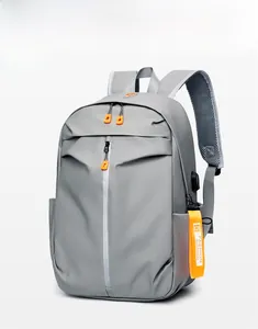 Detail of grey waterproof backpack with orange zippers and external USB charging port