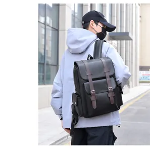 Outdoor shot of a man wearing a vintage black leather backpack with brown buckle straps
