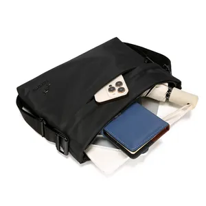 Black minimalist messenger bag showing interior capacity for tablets and daily essentials