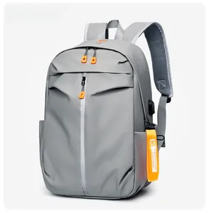 Detail view of water-resistant gray backpack with orange zipper pulls and side pockets