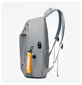 Detailed side view of grey waterproof backpack with USB port and orange fashion ribbon