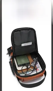 Macro view of high-capacity brown leather crossbody bag showing interior storage and lock