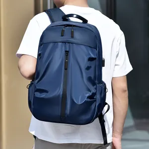 Sac à dos bleu marine avec port USB, porté par un modèle devant un bâtiment moderne