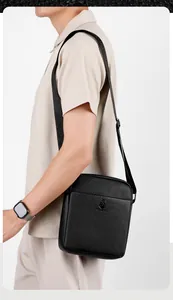 Close-up of pebble-grain leather texture and jacquard logo strap on men's crossbody bag