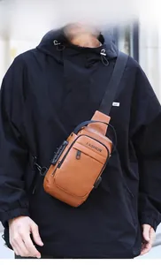 Close-up of brown PU leather chest bag with side TSA lock and integrated USB charging port