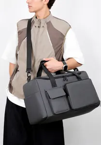Modello con borsa da viaggio grigio scuro con grande capacità e tracolla regolabile