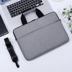 Sacoche grise pour ordinateur portable avec bandoulière et poche frontale sur bureau