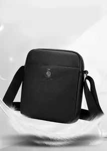 Close-up of black litchi pattern leather cross-body bag featuring a metallic animal logo