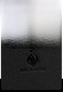 Detailed macro view of the embossed gentleman logo on black litchi grain leather