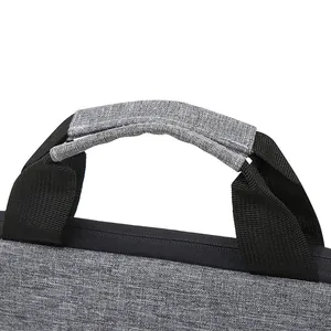 Detail of gray waterproof fabric texture and padded black nylon handle on laptop bag