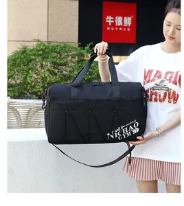 Detalle de bolsa de deporte negra con logo NICHAO GYM y correa de hombro ajustable