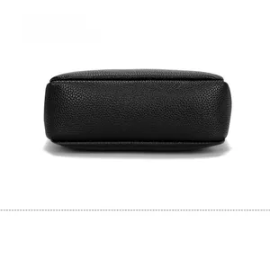 Close-up of pebble grain leather texture and neat stitching on black crossbody bag base