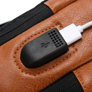 Brown leather crossbody bag with integrated USB charging port and white cable connector