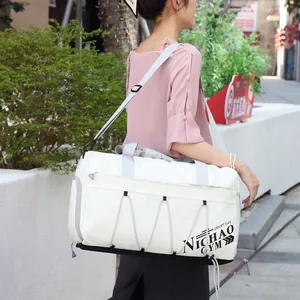 Large white sports gym bag with black lettering and adjustable shoulder strap shown on a model