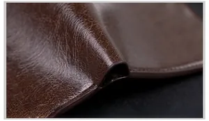 Macro shot of dark brown leather wallet showing smooth oil edge and tight stitching