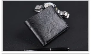Close-up of black bifold leather wallet with pebble grain texture on a professional desk