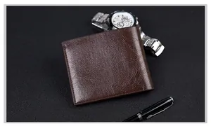 Detail of dark brown leather wallet with fine stitching next to a watch and pen