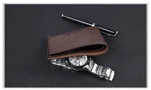 Close-up of slim dark brown leather bifold wallet stacked with business accessories