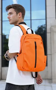 Outdoor view of a vibrant orange waterproof backpack with side pockets and black straps