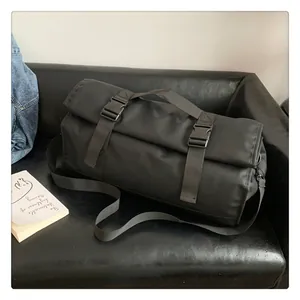 Detalle de bolsa de viaje negra impermeable con hebillas en un sofá de cuero