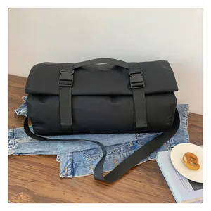 Detalle de la bolsa de viaje negra con correas de hebilla y asa de nylon duradera