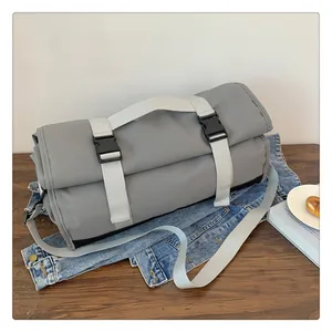 Detalle de la bolsa de viaje gris grande con hebillas de plástico y asas de correa
