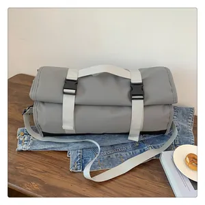 Primer plano de bolsa de viaje gris impermeable sobre mesa de madera y chaqueta denim