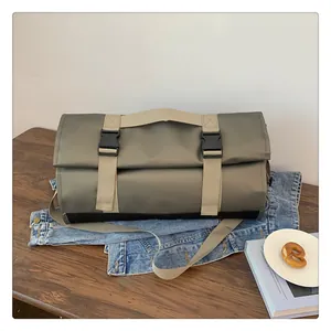 Primer plano del bolso de viaje verde oliva sobre chaqueta denim con correas y base