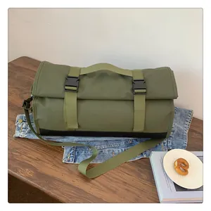 Detalle de bolsa de viaje impermeable verde militar con hebillas y correa ajustable