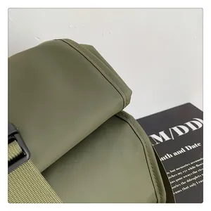Detalle de tela impermeable verde militar mate con hebilla en la mochila de viaje