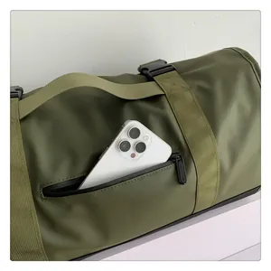 Detalle del bolsillo lateral en la bolsa de viaje verde mostrando espacio para móvil
