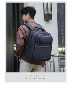 Modèle masculin portant un sac à dos business gris foncé imperméable avec bande réfléchissante