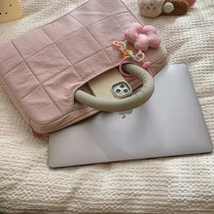 Rosa gesteppte 16-Zoll-Laptoptasche mit grünem Griff und Blumenanhänger in gemütlichem Heim