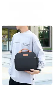 Détail du sac à déjeuner noir portable avec plusieurs poches et poignées marron