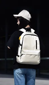 Detailed back view of a large capacity cream backpack on a model in an outdoor setting