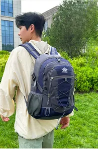 Outdoor hiking backpack in blue and gray with bungee system shown from a side-rear view