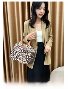 Vue détaillée du sac isotherme à motif léopard avec poche en filet et poignées marron