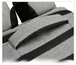 Detail of grey fabric backpack handle with breathable black mesh padding for comfort