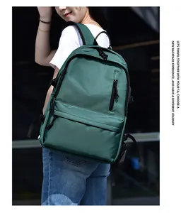 Side view of dark green waterproof backpack on model in an urban outdoor setting