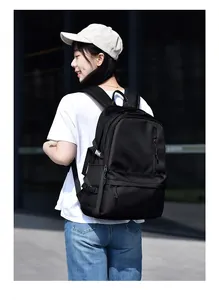 Outdoor shot of a black waterproof large-capacity backpack with side buckles and wide straps