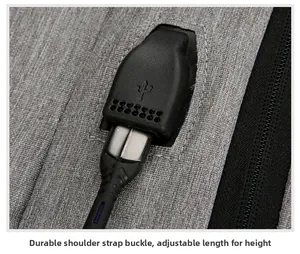 Macro detail of the integrated USB charging port on a grey textured travel backpack