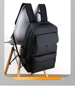 Minimalist black travel backpack with multiple pockets shown on a white chair