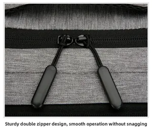Close-up of sturdy black double zipper system on a grey travel backpack fabric