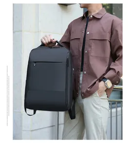 Business laptop backpack in matte black waterproof fabric shown on model in outdoor setting
