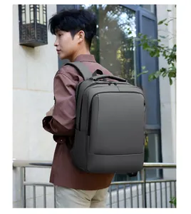 Outdoor lifestyle view of a model wearing the dark grey waterproof laptop backpack
